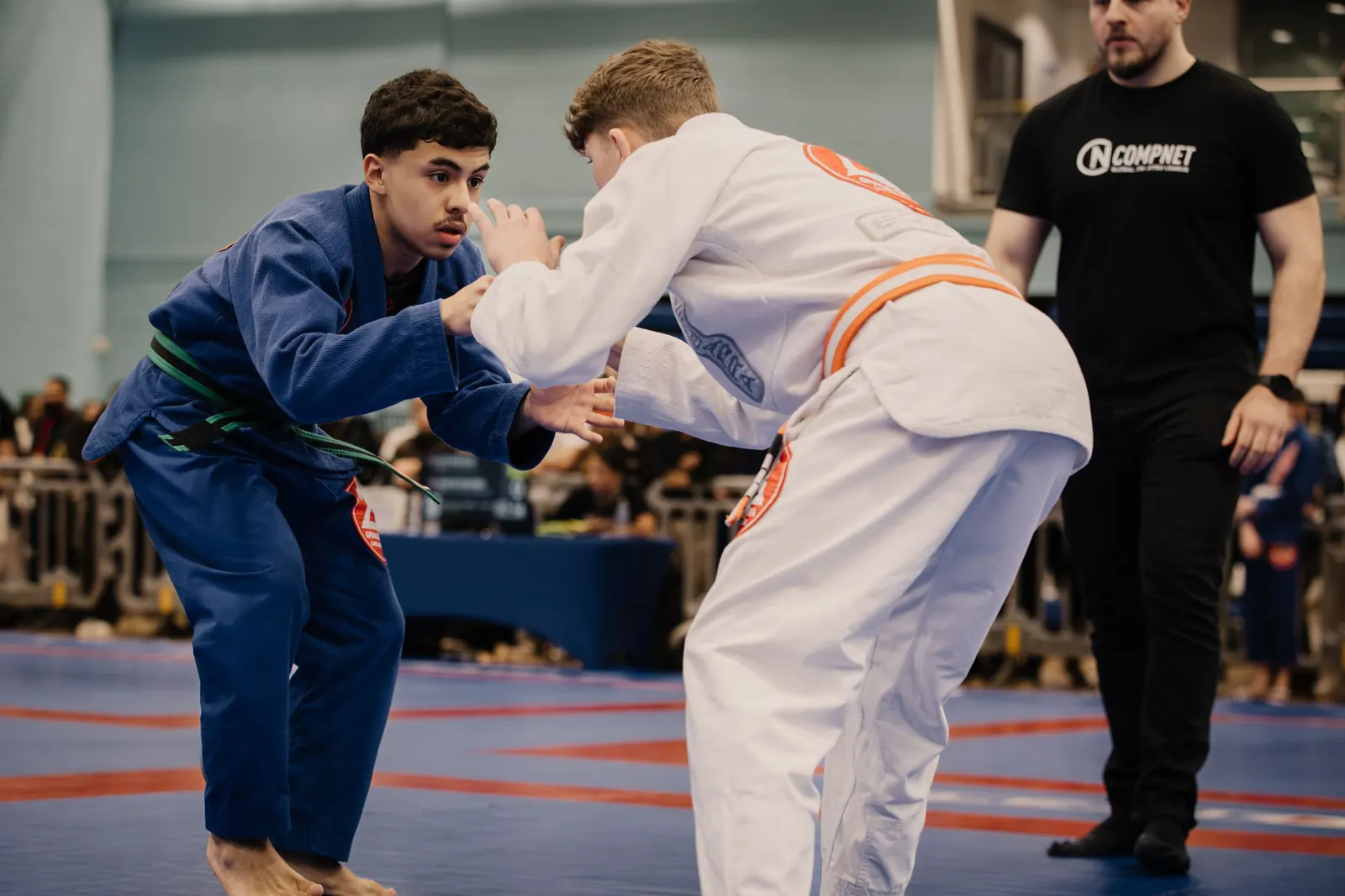 Two teenage students in blue and white gis beginning a standing round